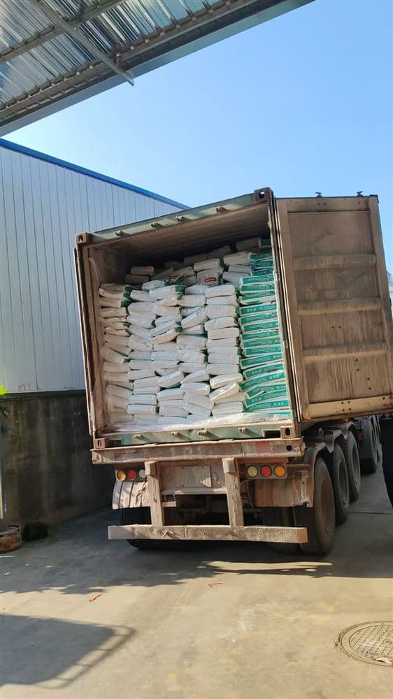 A shipping container fully loaded with bags of material